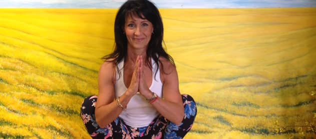 Denise demonstrating a yoga squat, known as the Goddess Pose.